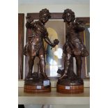 A pair of bronzed spelter figurines depicting chil
