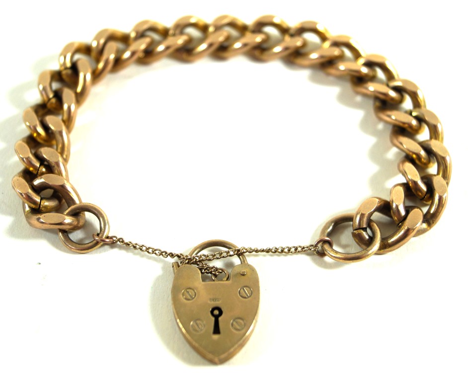 A 9ct gold curb link bracelet With a heart padlock and safety chain attached, weight 56.