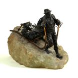 A bronze figure of a Alpine huntsman dragging a dead deer on a sledge late 19th Century The figure