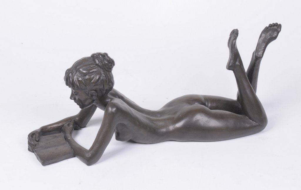 A bronze resin sculpture of a female figure Titled 'Anya with book',