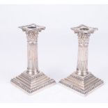 An Edwardian pair of silver Corinthian candlesticks Of typical form,