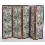 A mahogany framed five fold room screen The frame with brass embellishments and each panel covered