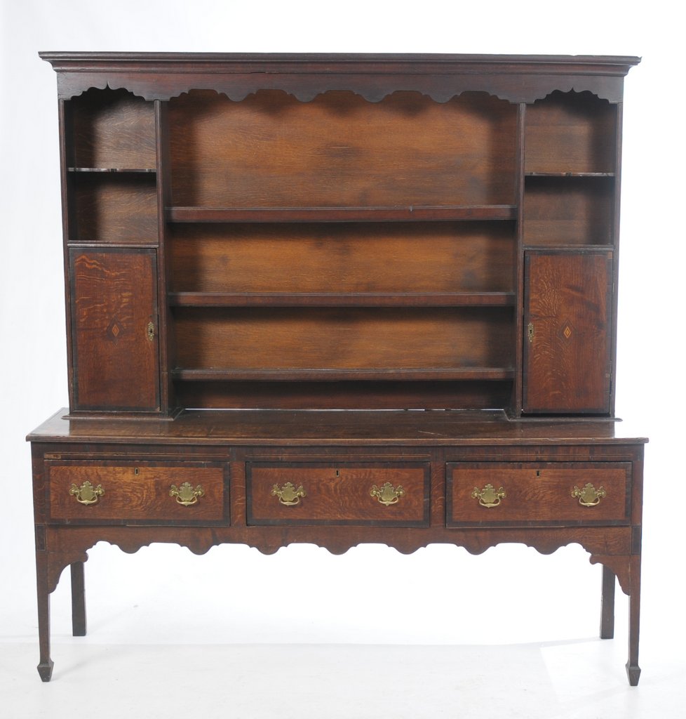 An 18th Century oak highback dresser With a cavetto cornice above a shaped scalloped frieze and