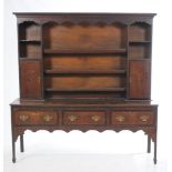 An 18th Century oak highback dresser With a cavetto cornice above a shaped scalloped frieze and
