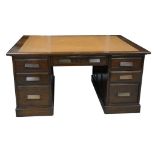 An early 20th Century oak partners desk The rectangular top inset with a tan leather and a gilt