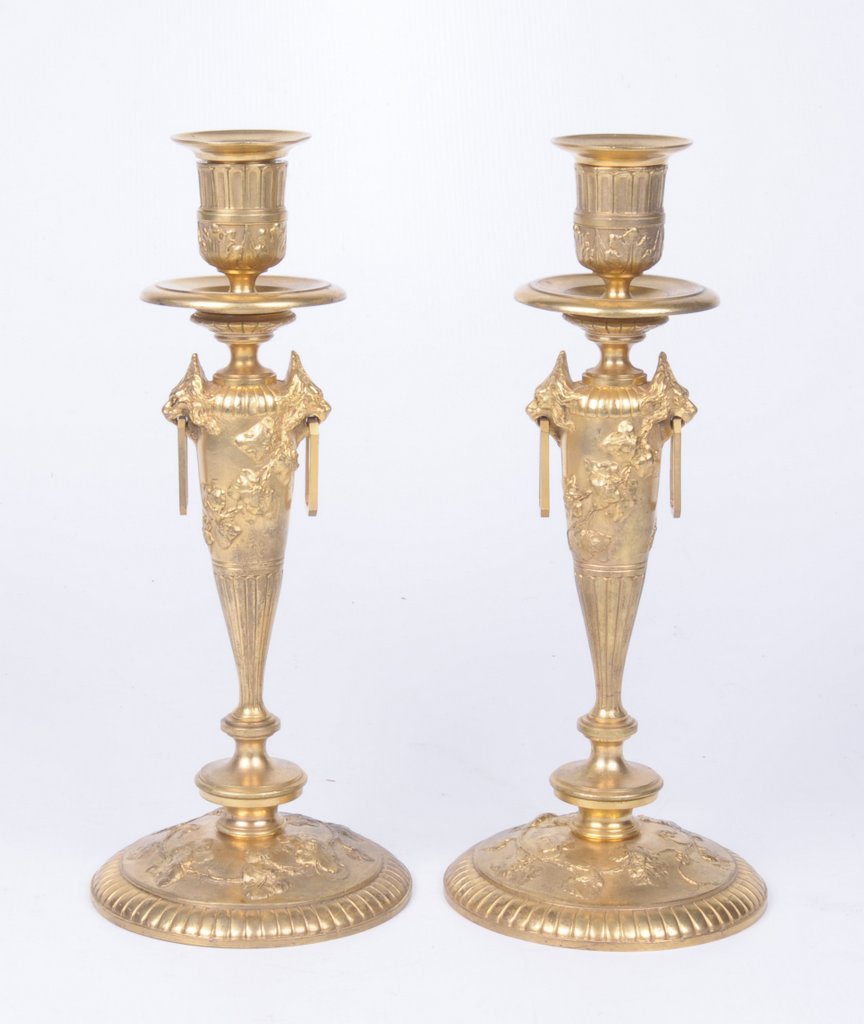 A pair of gilt metal French Louis XVl style candlesticks Each rising from a spreading circular