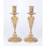 A pair of gilt metal French Louis XVl style candlesticks Each rising from a spreading circular