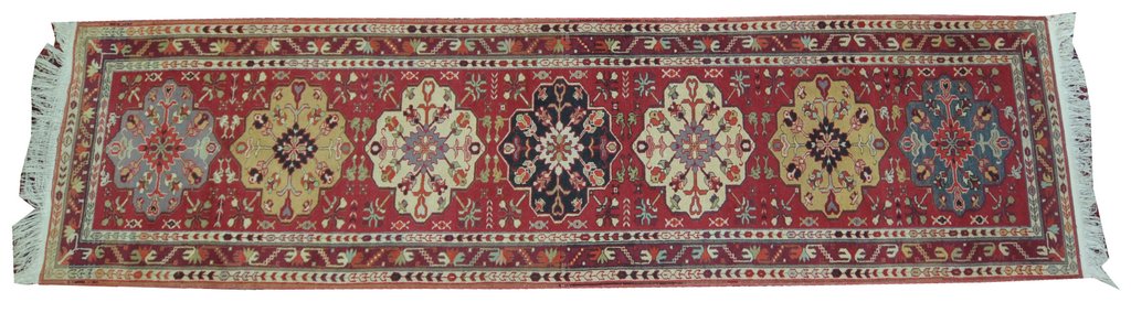 A Turkish style medallion runner of elongated rectangular form, on a predominantly red ground,