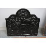 A Victorian cast iron fire back The shield shaped panel, cast in an earlier manner with lion,