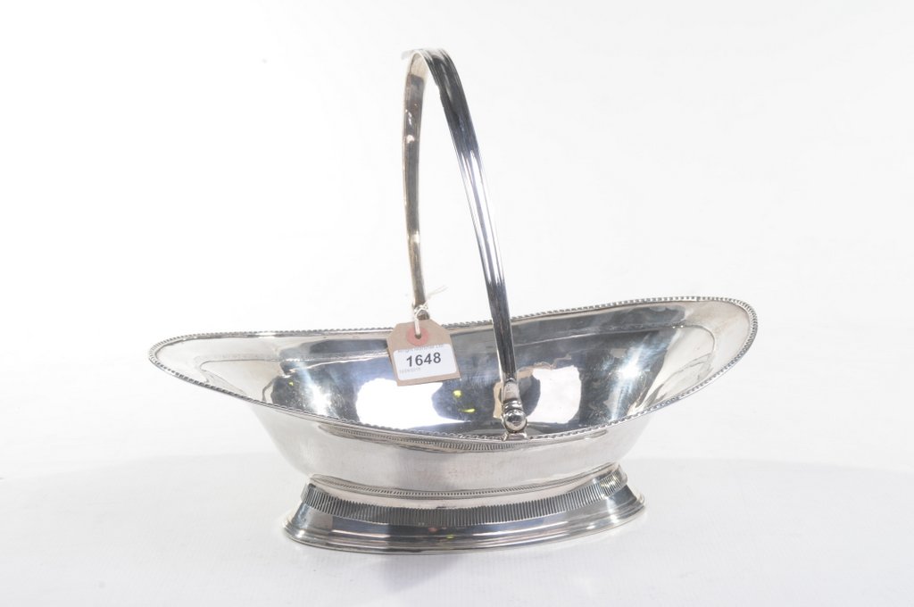 A Georgian silver swing -handled basket Raised on a swept pierced gallery base,