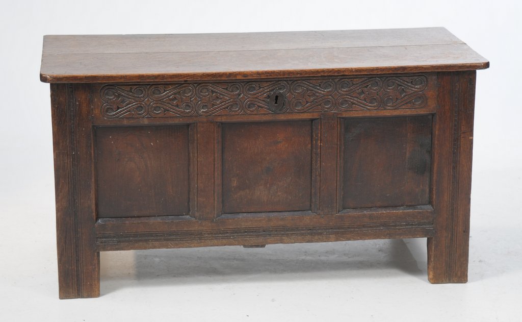 A small 17th/18th Century panelled oak coffer The two plank lid with iron hinged brackets,