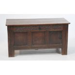 A small 17th/18th Century panelled oak coffer The two plank lid with iron hinged brackets,