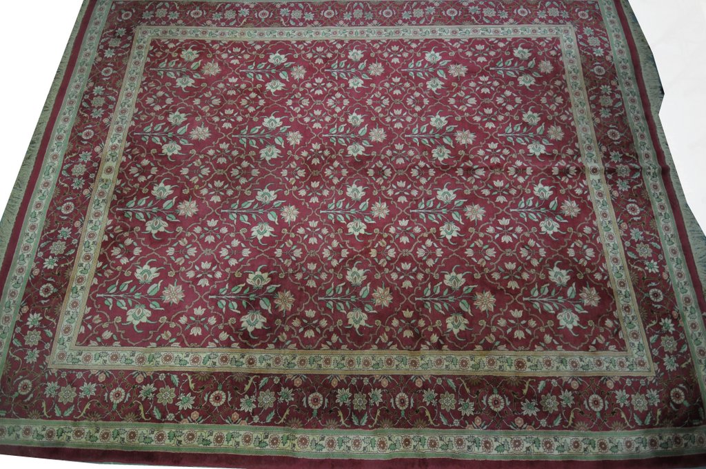 A modern Bokhara style carpet The large rectangular carpet to a predominantly ruby red ground,