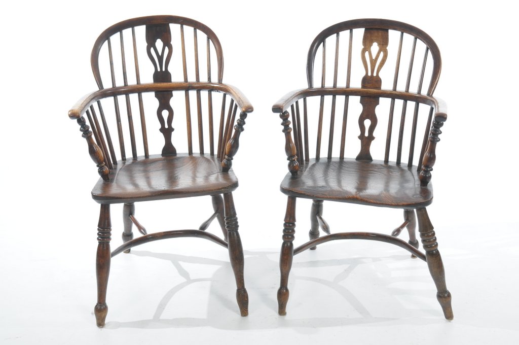 A near pair of 19th Century elm Windsor elbow chairs Each with a hooped back and a central pierced