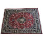 A Persian Kashan style medallion rug The large rug on a predominantly ruby red ground with central