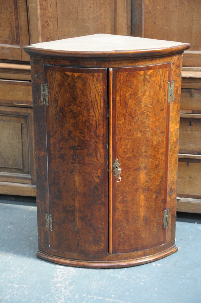 An unusual late 18th Century pollard oak bowfront hanging corner cupboard,