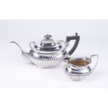 A Victorian silver tea pot and milk jug Of ovoid form, with an embossed fluted lower body,