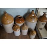 Seven vintage stoneware spirit flagons, including Bulmers Cider, Wells & Winch of Biggleswade,