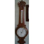 A late Victorian/Edwardian carved oak cased wheel barometer/thermometer,