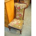 A Victorian mahogany prie dieu chair with a scroll flowerhead crest above a padded back raised on