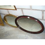 An Oval mahogany farmed wall mirror and a gilt framed oval mirror.