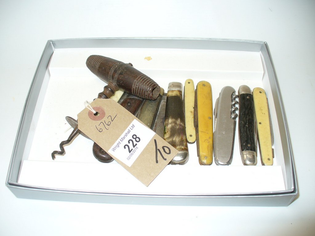 Nine assorted pocket knives and a vintage corkscrew with a turned wooden handle.