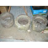 A collection of three weathered reconstituted stone garden planters Each of cylindrical form,