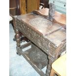 A 17th Century and later constructed oak hall stand with a carved figure above a hinged glove box,