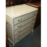 A white Continental style chest of five long drawers.