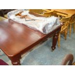 A Victorian style extending mahogany dining table on reeded tapering legs and brass castors,