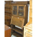 An early 20th Century oak bureau bookcase with two glazed doors above a fall front and two open