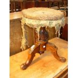 A Victorian walnut adjustable piano stool with three down swept supports and scroll toes.