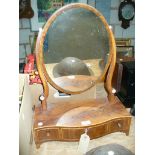 A 19th Century mahogany oval dressing table mirror on a three drawer serpentine plinth.