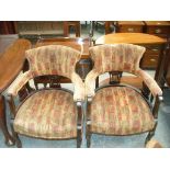 A Pair of Victorian tub chairs each with a padded arm rail raised on three pierced splats.