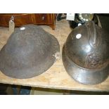 A French WWI metal helmet mounted with a lions mask and a British army helmet.