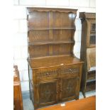 A reproduction oak dresser the high back with two enclosed shelves above two drawers and two