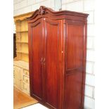 A Stained wood French style double wardrobe with a scroll pediment above two panelled doors,