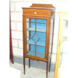 An Edwardian inlaid mahogany display cabinet with a single astragal glazed door raised on legs of