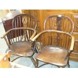 A near pair of 19th Century elm Windsor elbow chairs Each with a hooped back and a central pierced