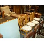 A Set of four beech wheel back kitchen chairs and a formica top table.