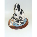 A Border Fine Art group , black and white spaniel with pups, raised on a hardwood plinth.