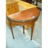 A Mahogany half moon folding tea table with a gadroon border,