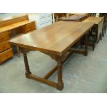 An Oak Gothic refectory table on ring turned cylindrical supports with plain cross stretchers.