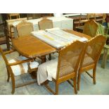 A Continental style extending dining table with 6 conforming rattan back chairs.