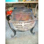 A Victorian cast iron fire basket with a cast sunburst and serpentine back.