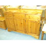 A Modern pine sideboard with three drawers over three cupboard doors.