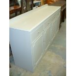 A Painted sideboard with four drawers above four cupboard doors.