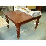 A Victorian style extending mahogany dining table on reeded tapering legs and brass castors,