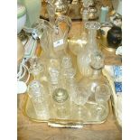 Two bulbous glass decanters, cruet bottles and other glass ware to a tray.