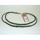 A double string of green beads, of graduated form,